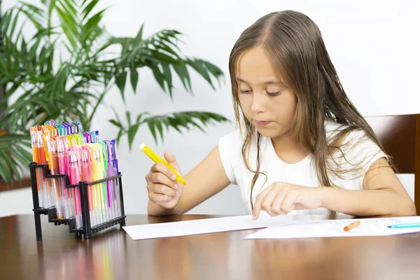 Söt flicka sitter vid sitt skriv bord målning — Stockfoto