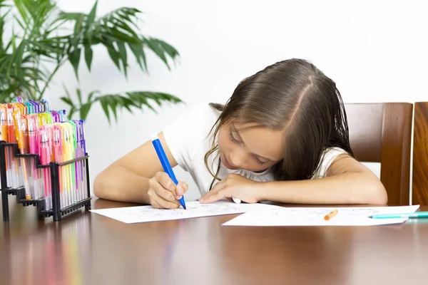 Menina bonito sentado em sua mesa Pintura — Fotografia de Stock