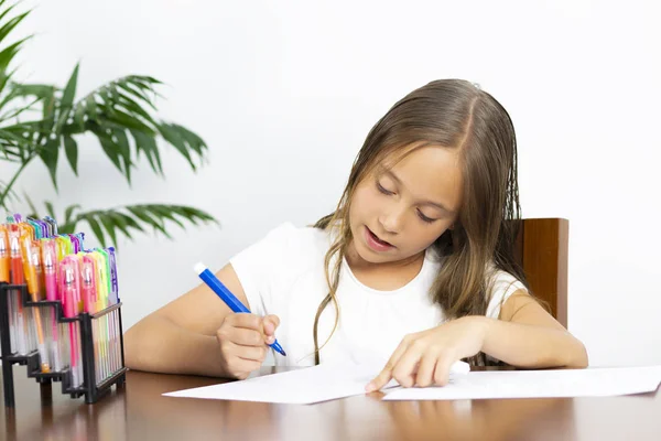 Menina bonito sentado em sua mesa Pintura — Fotografia de Stock