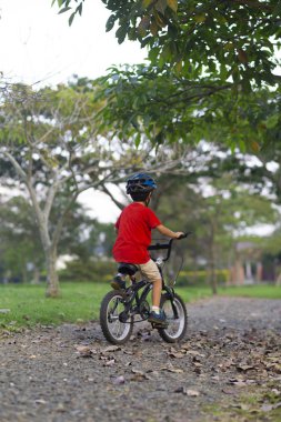 Bir bisiklet sürme neşeli küçük çocuk