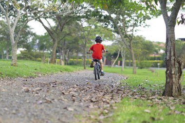 Bir bisiklet sürme neşeli küçük çocuk
