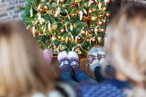 Noel çorap Noel ağacının yanında oturan iki kadın giyinmiş — Stok fotoğraf