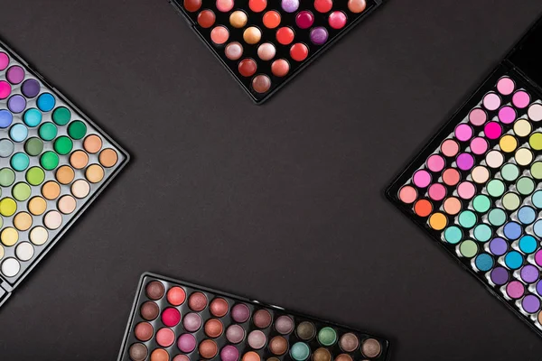 Colorful make-up eyeshadow palettes on black background — Stock Photo, Image