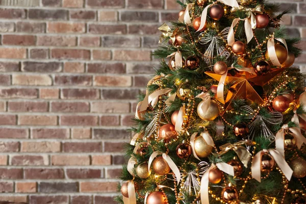 Albero di Natale decorato contro muro di mattoni — Foto Stock