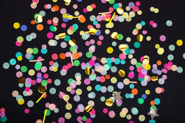Vue du dessus des confettis colorés sur fond noir — Photo