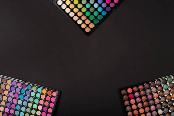 Make-up eyeshadow palettes on black background with copy space — Stock Photo, Image