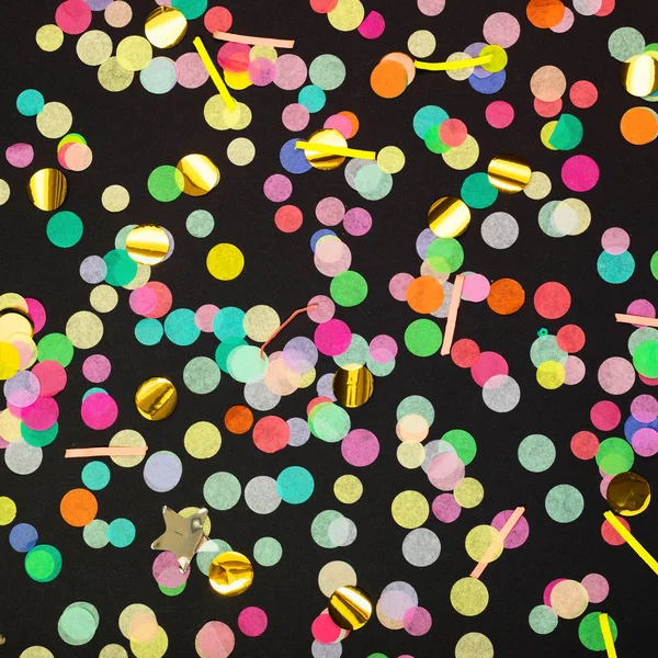 Colorful confetti scattered on black background — Stock Photo, Image