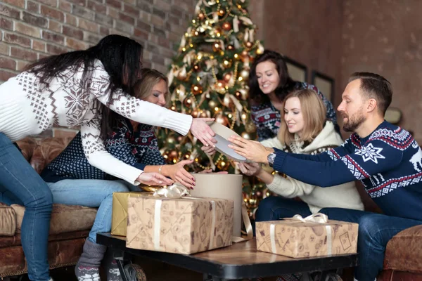 Jóvenes abriendo cajas de regalo de Navidad junto a un árbol de Navidad —  Fotos de Stock