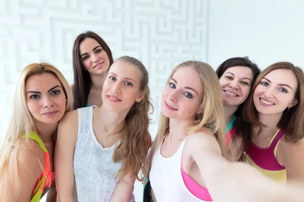 Grupo de jovens mulheres atraentes vestidas com roupas esportivas tirando selfie — Fotografia de Stock
