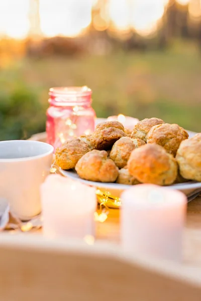 Вкусное печенье со свечами на деревянном подносе на открытом воздухе — стоковое фото