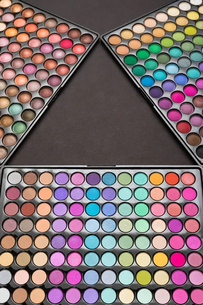 Vista superior de las paletas de sombra de ojos como fondo de maquillaje colorido — Foto de Stock