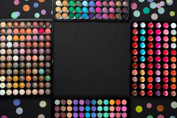 Makeup eyeshadow palettes with colorful confetti on black background — Stock Photo, Image