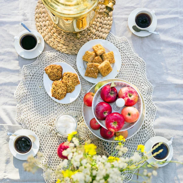 Vista dall'alto su un tavolo con samovar russo, tazze di caffè, mele e biscotti — Foto Stock