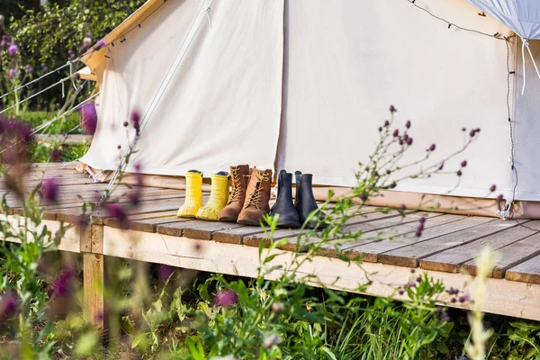 Close-up of a canvas bell tent with shoes on a wooden base — Stock Photo, Image