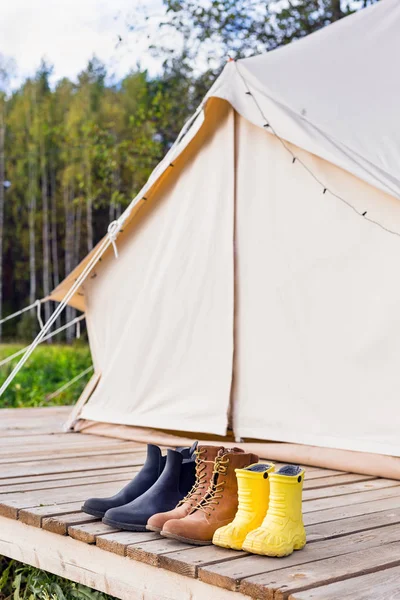 Three pair of shoes near bell tent — Stock Photo, Image