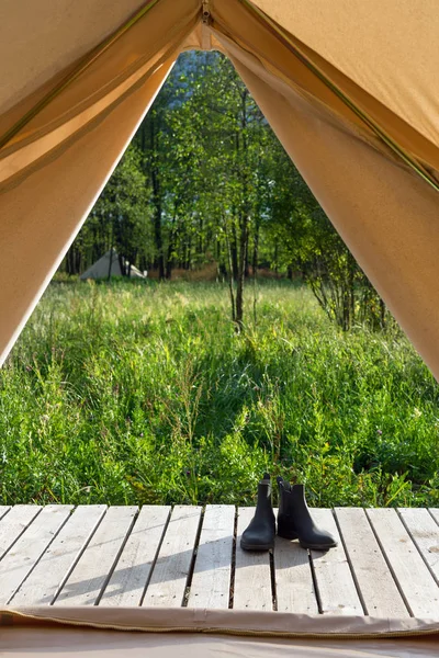 Pair of shoes near canvas tent at forest — Stock Photo, Image