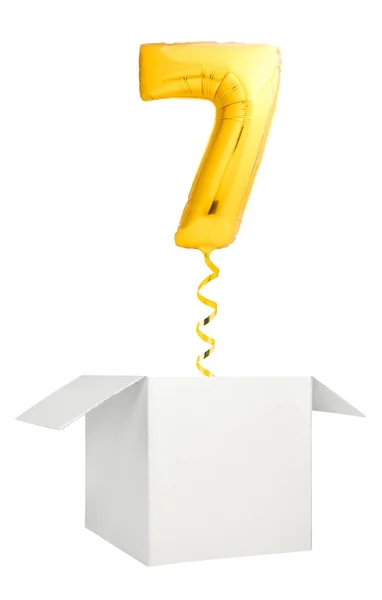 Globo dorada número siete volando fuera de caja blanca en blanco aislado sobre fondo blanco —  Fotos de Stock