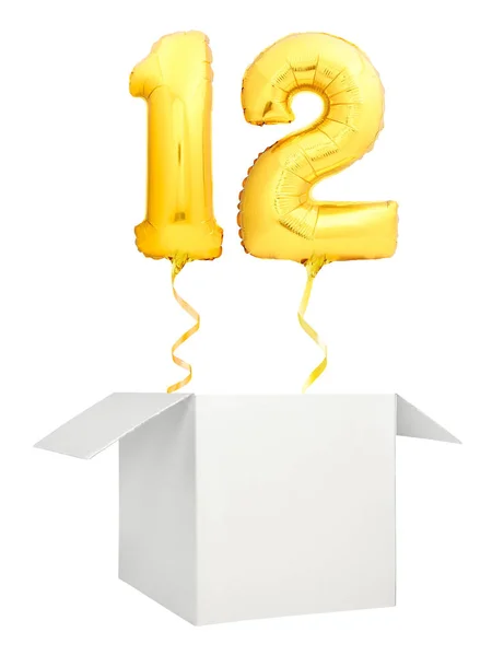Gouden nummer twaalf ballon vliegen uit lege witte doos geïsoleerd op witte achtergrond — Stockfoto
