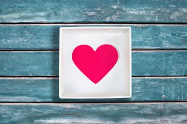 Kağıt kalp vintage mavi ahşap arka plan üzerinde beyaz karton kutu içinde pembe