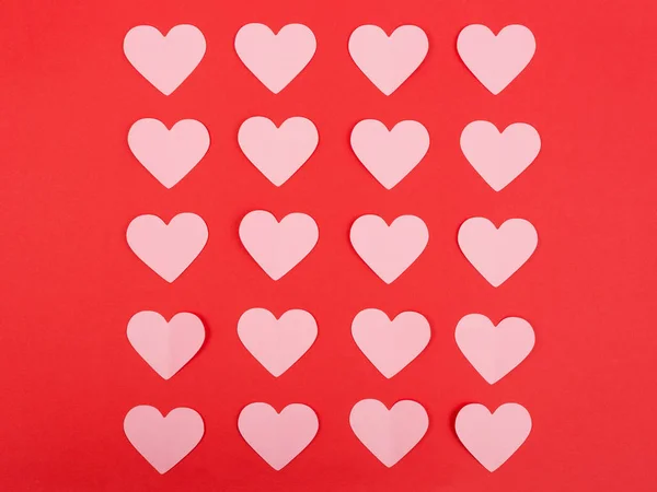 Pink paper hearts on red background — Stock Photo, Image