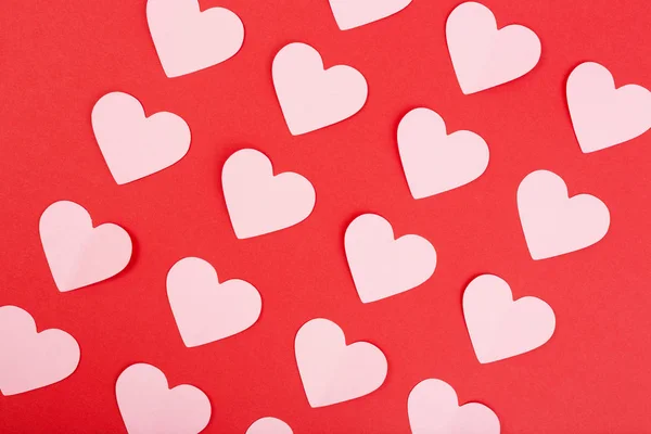 Pink paper hearts on red background. Flat lay — Stock Photo, Image