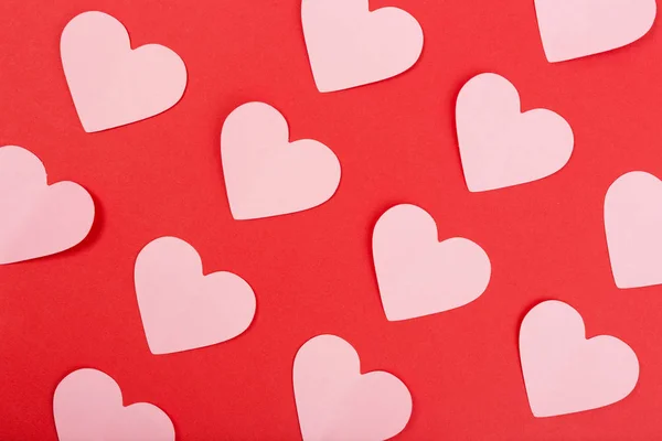 Pink paper hearts on red background. Flat lay — Stock Photo, Image