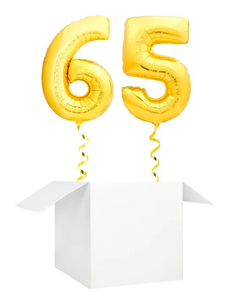 Golden number sixty five inflatable balloon with golden ribbon flying out of blank white box isolated on white background — Stock Photo, Image