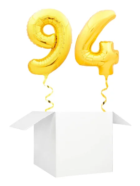 Número dourado noventa e quatro balão inflável com fita dourada voando para fora da caixa branca em branco isolado no fundo branco — Fotografia de Stock