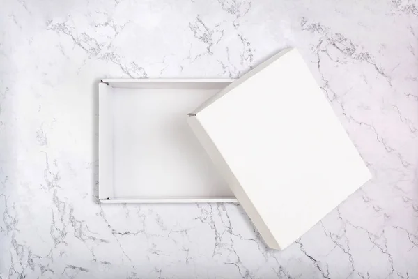 오픈 커버 흰색 대리석 바탕에 흰색 골 판지 상자. 평면 배치 — 스톡 사진