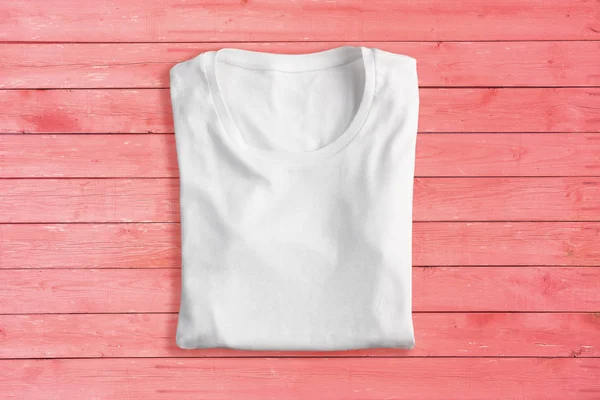 White folded t-shirt on pink background — Stock Photo, Image