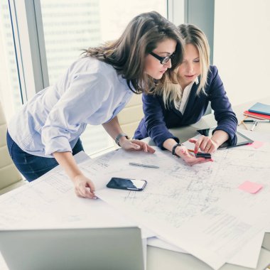 Proje üzerinde çalışırken telefon kullanarak iki kadın arkadaşları akıllı