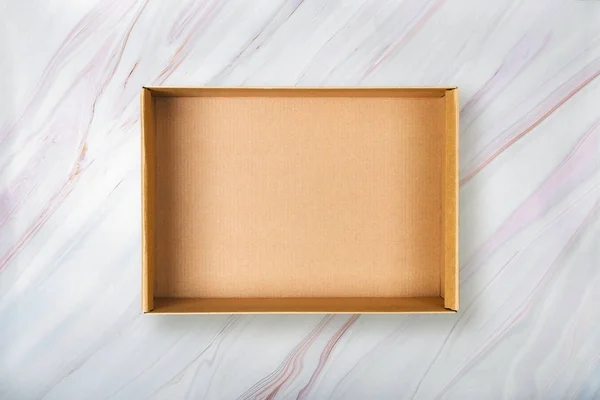 천연 대리석 질감에 골 판지 상자입니다. 대리석 백그라운드에 빈 열기 상자의 플랫 누워 — 스톡 사진