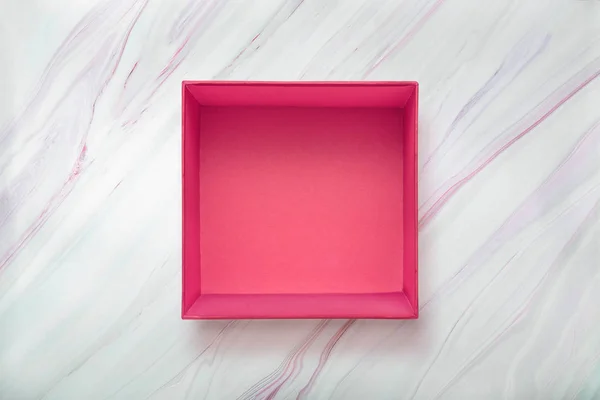 Caja de regalo rosa en blanco abierto sobre fondo de mármol natural. Caja de cartón rosa sobre textura marbe . — Foto de Stock