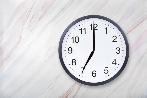 Wall clock show seven oclock on marble texture. Office clock show 7pm or 7am — Stock Photo, Image