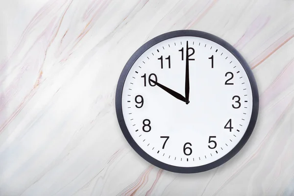 Настенные часы показывают десять часов на мраморной текстуре. Часы в офисе показывают 10 вечера или 10 утра — стоковое фото