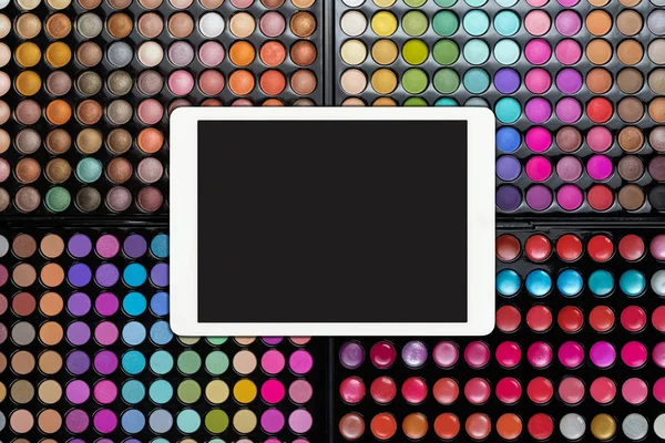 Witte touchpad met leeg scherm op kleurrijke oogschaduw paletten. Oogschaduw make-up paletten met tablet pc — Stockfoto