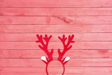 Düz başı bir geyik kafa bandı pembe ahşap zemin üzerinde yatıyordu