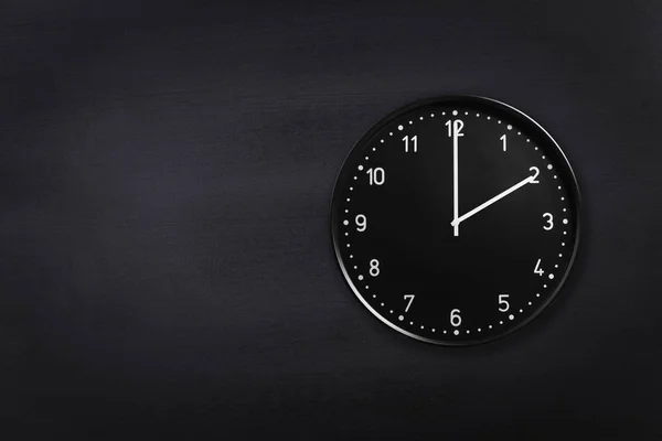 Horloge murale montrant deux horloges sur fond de tableau noir. Horloge de bureau montrant 2h ou 14h sur texture noire — Photo
