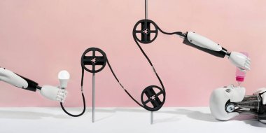 Plastik jantlar ve pembe arka plan üzerinde robot elleri ile yaratıcı robotik konveyör kavramı. Robot besleme konsepti