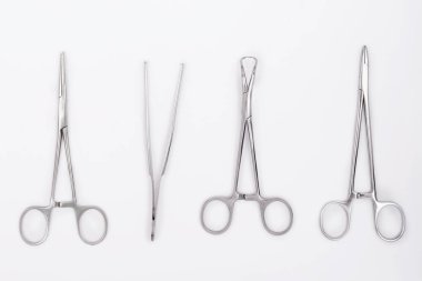 Beyaz arka planda metal cerrahi aletler. Düz yatıyordu