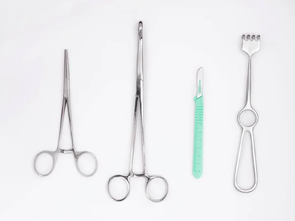 Flat lay of metal surgical tools on white background — Stock Photo, Image