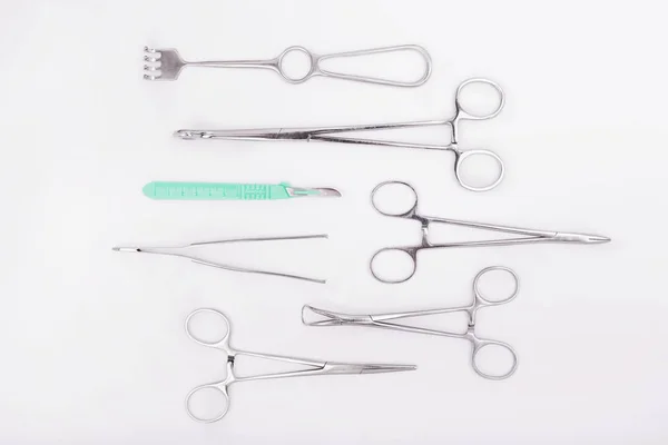 Conjunto de instrumentos quirúrgicos metálicos sobre fondo blanco. Instrumentos quirúrgicos plásticos — Foto de Stock