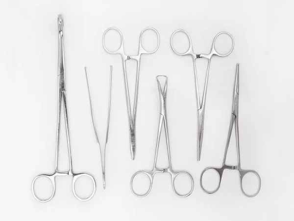 Strumenti chirurgici in acciaio inox su sfondo bianco lay groundlat — Foto Stock