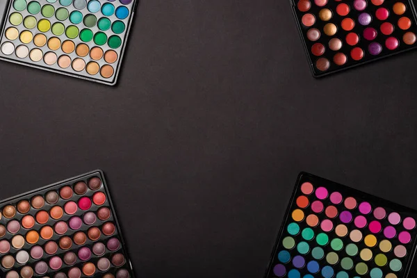 Eyeshadow palettes on black background with a place for your copy space — Stock Photo, Image
