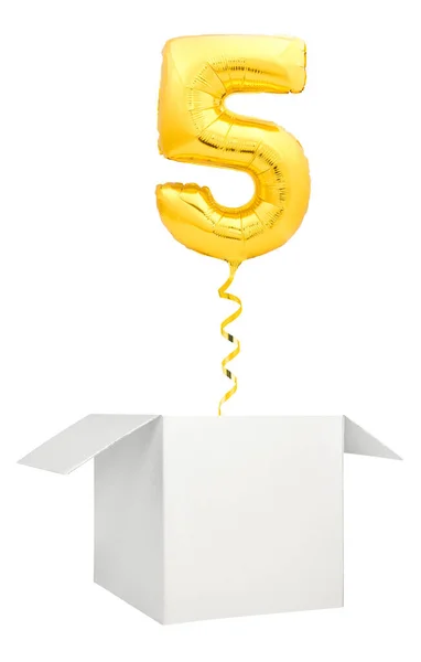 Globo dorado número cinco volando fuera de caja blanca en blanco aislado sobre fondo blanco — Foto de Stock