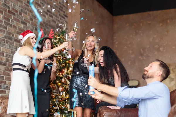 Jovens pessoas felizes se divertindo na festa Ney Years com confete e champanhe no loft moderno — Fotografia de Stock