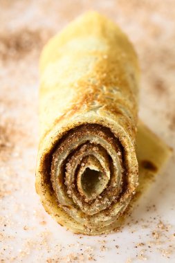 Krep rulo tarçın ve şeker, doğal ışık (seçici odak, odak ön tarafında rulo ile fotoğraflandı dolu)