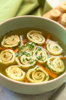 Geleneksel Alman Flaedlesuppe ve Avusturya ile consomme dayalı Frittatensuppe rulo veya çizgili krep ve gözleme chives, doğal ışık (seçici odak, odak üçte biri haline görüntü ile fotoğrafı ile süslenmiş)