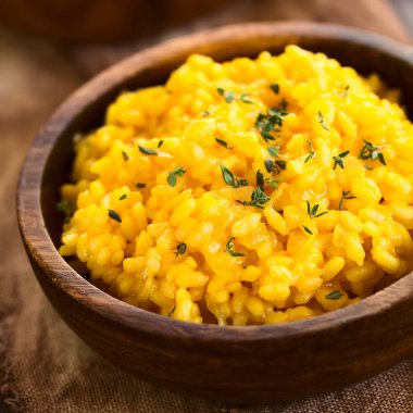 Kabak risotto kabak püresi ile hazırlanan ve doğal ışık (seçici odak, odak üçte biri haline risotto ile fotoğraflandı ahşap kase hizmet taze kekik yaprakları serpilir)