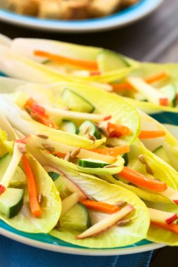 Hindiba, taze salata yaprakları, salatalık, havuç, elma ve ayçiçeği tohumu, doğal ışık (seçici odak, odak üçte biri haline salata ile fotoğrafı)